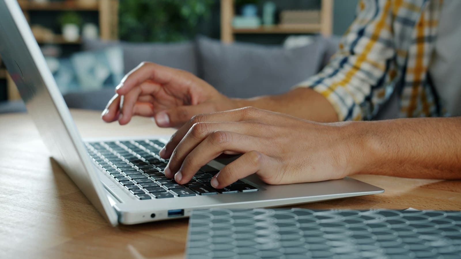 Hands typing on a laptop