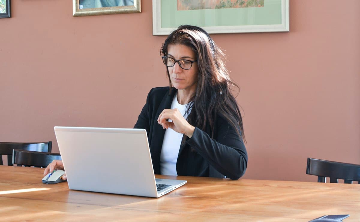An administrator with glasses works on her laptop